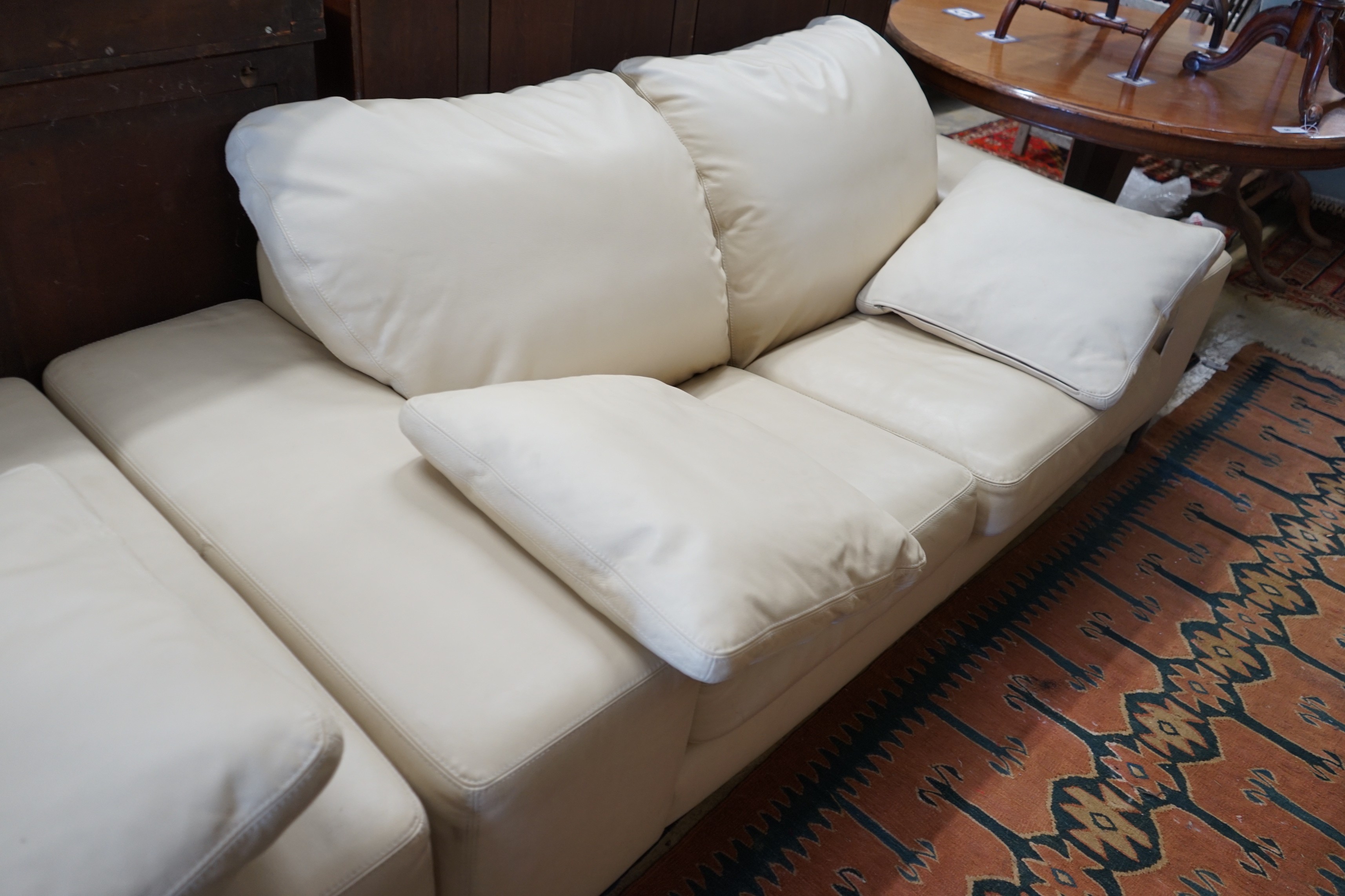 A contemporary Italian design cream leather three seater and two seater settee, larger length 210cm, depth 96cm, height 80cm